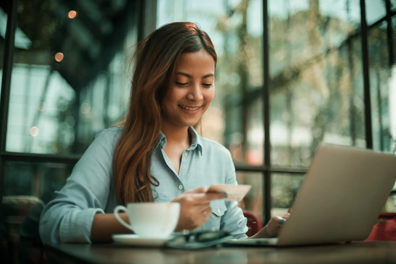 woman_holding_credit_card_laptop_coffee(WHCCLC) woman holding credit card laptop coffee(WHCCLC)